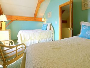 An interior of a room with a twin bed and a lampshade.